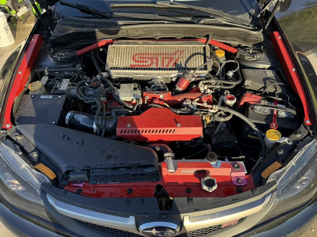 Engine bay with red strut bar, radiator shroud and top-mount intercooler